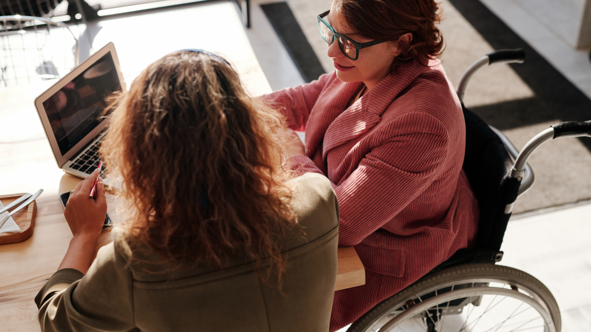 Noia en cadira de rodes mirant un ordinador.